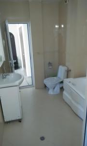 a white bathroom with a toilet and a sink at Apartment 54 Ryor in Sunny Beach
