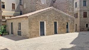 a small stone building in front of a building at Affittacamere Faber in Tempio Pausania