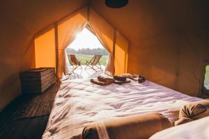 un grande letto in una tenda con due sedie di Muuski glempings a Korneti