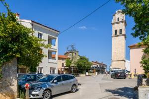 un'auto parcheggiata in un parcheggio con una torre dell'orologio di MA Premantura Luxury Apartments Ferienwohnung - Premantura Pula Istria a Premantura