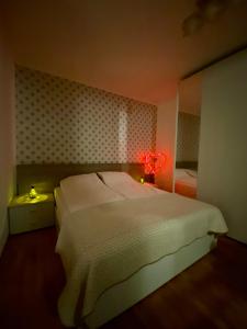 イゾラにあるPrimavera Apartmaのベッドルーム(白いベッド1台、赤いランプ付)