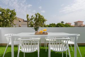 a white table and four chairs on a patio at iloftmalaga Ático Carihuela in Torremolinos