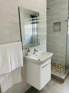 a white bathroom with a sink and a mirror at Unit 3, Marine Terrace in Margate