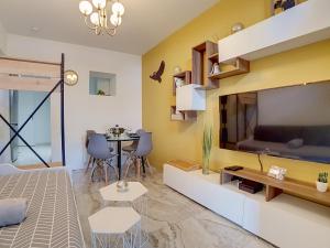 un salon avec une grande télévision et une table dans l'établissement Stop Chez M Select Garden # Qualité # Confort # Simplicité, à Saint-Fons