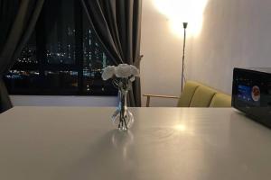 un vase de fleurs assis sur une table avec une fenêtre dans l'établissement KB22, Cyberjaya, Netflix, WiFi, Free Parking, 1010, à Cyberjaya