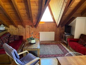 ein Wohnzimmer mit roten Sofas und einem Fenster in der Unterkunft Chalet Les Rhodos appartement le Yeti in Les Crosets