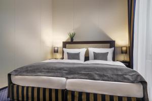a bedroom with a large bed with pillows at Novum Hotel Continental Hamburg Hauptbahnhof in Hamburg