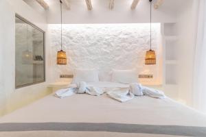 a bedroom with a white bed with two towels on it at Nikos Apartments and Studios in Agios Prokopios