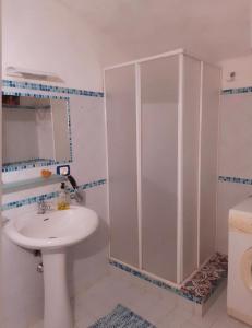 baño blanco con ducha y lavamanos en Le Volte, en Ragusa