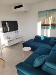 a living room with a blue couch and a tv at Haus Dalmatia with heated Pool in Bibinje +98 photos