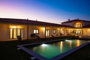 a villa with a swimming pool at night at Refúgio da Rainha in Moledo