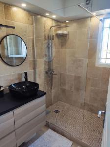 a bathroom with a shower with a sink and a mirror at Harmonie du sud in Le Grau-dʼAgde