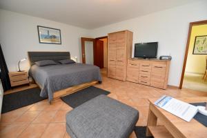 a bedroom with a bed and a flat screen tv at Haus "Luv und Lee" Appartement LEE19 in Döse