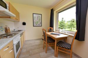 a kitchen with a table and chairs and a window at Haus "Luv und Lee" Appartement LEE19 in Döse