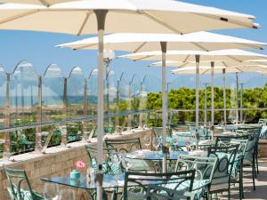a row of tables and chairs with umbrellas at Hotel Quinta do Lago in Quinta do Lago