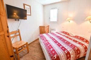 1 dormitorio con 1 cama y TV de pantalla plana en Flat In Residence With Swimming Pool, en Saint-Gervais-les-Bains