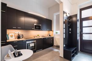 a kitchen with black cabinets and a white table at Double Blue Apartment in Budapest Downtown in Budapest