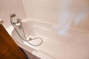 y baño con bañera blanca y ducha. en Flat In Residence With Swimming Pool, en Saint-Gervais-les-Bains