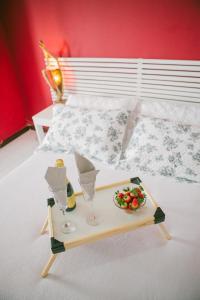 a tray with two glasses and a bowl of fruit on a bed at B&B JPA Casa ANSELMO in Salvador +48 photos