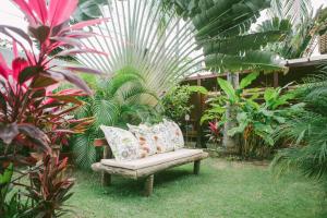 a bench in the middle of a garden with plants at B&B JPA Casa ANSELMO in Salvador