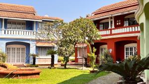 un patio de un edificio con árboles y césped en Rosewood By The Beach Goa en Benaulim