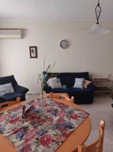 a living room with a table with a floral table cloth at Luminosa Village Apartment in Iraklitsa