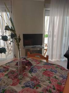 a vase with flowers on a table in a room at Luminosa Village Apartment in Iraklitsa