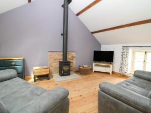 a living room with two couches and a fireplace at Spindle Cottage in York