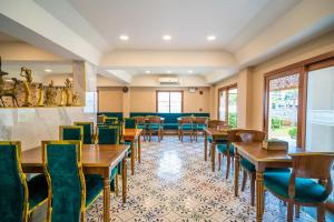 a restaurant with wooden tables and green chairs at Siri Nakornpink Chiang Mai Hotel SHA Plus in Chiang Mai