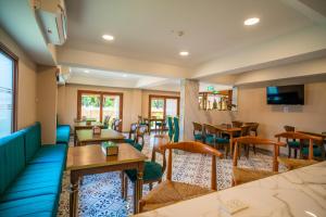 a restaurant with tables and chairs and a tv at Siri Nakornpink Chiang Mai Hotel SHA Plus in Chiang Mai