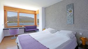 a bedroom with a bed and a desk and a window at Posada del Agua in El Barraco