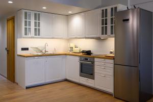 a kitchen with white cabinets and a stainless steel refrigerator at Plato 88 in Kalamata
