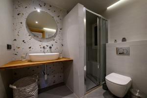 a bathroom with a sink and a toilet and a mirror at Plato 88 in Kalamata +60 photos