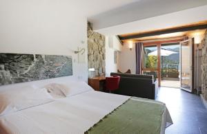 a bedroom with a white bed and a sliding glass door at Posada del Agua in El Barraco