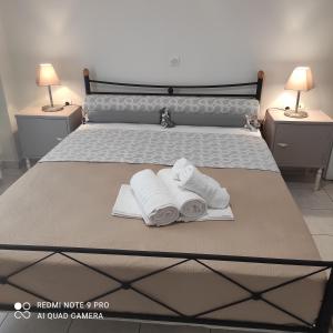 a bedroom with a bed with towels and two lamps at ARETI4 in Petalidi