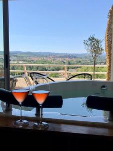 twee glazen wijn zittend op een tafel naast een bad bij Panorama Suite romantique & Spa in Carcassonne