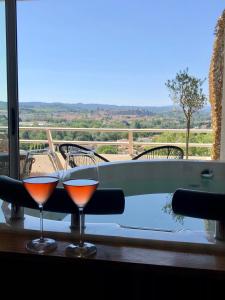 due bicchieri di vino seduti su un tavolo accanto a una vasca da bagno di Panorama Suite romantique & Spa a Carcassonne