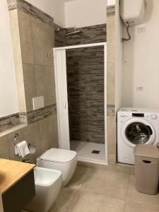 a bathroom with a toilet and a washing machine at CASA ARUCI in Avola +26 photos