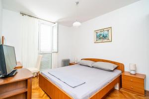 1 dormitorio con 1 cama y escritorio con TV en Apartment Klaudia en Dubrovnik