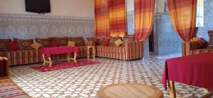 a living room with couches and tables and a television at Villa Chouiter Center in Marrakesh