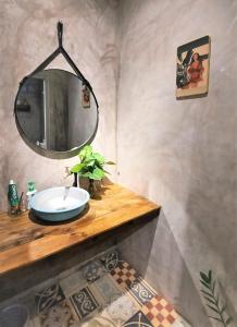 ein Badezimmer mit einem Waschbecken und einem Spiegel auf der Theke in der Unterkunft Vườn Nhà Ngoại Garden Homestay in Cu Chi