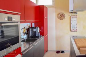 a red kitchen with a sink and a microwave at Bed, boat and beach in Feriolo direkt am See in Baveno