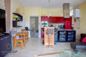 a kitchen and living room with red cabinets and a table at Bed, boat and beach in Feriolo direkt am See in Baveno