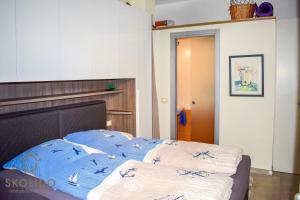 a bedroom with a bed with blue and white sheets at Bed, boat and beach in Feriolo direkt am See in Baveno
