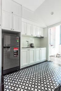 a kitchen with white cabinets and a black and white tile floor at Ngan Ha 2 Apartments in Ho Chi Minh City