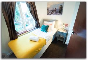 małe łóżko z oknem w pokoju w obiekcie BridgeCity 3 bed House in Maidstone Town Centre w mieście Kent