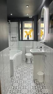 een badkamer met een bad, een toilet en een wastafel bij Harbour Cottage in Folkestone