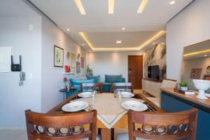 ein Esszimmer und ein Wohnzimmer mit Tisch und Stühlen in der Unterkunft Ap. Alto padrão Costa Azul 200m da praia | ROTR304 in Rio das Ostras