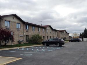 a car parked in a parking lot in front of a building at Travelodge by Wyndham Hudsonville in Hudsonville