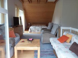 a living room with a couch and a bed at Haus Rosengarten- Ruhige Ferienwohnungen im Grünen in Sehlen